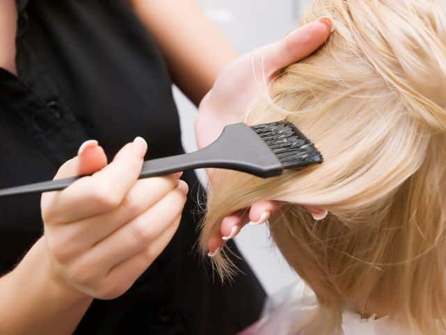 applying the bleach wash mixture with a tinting brush on damp hair